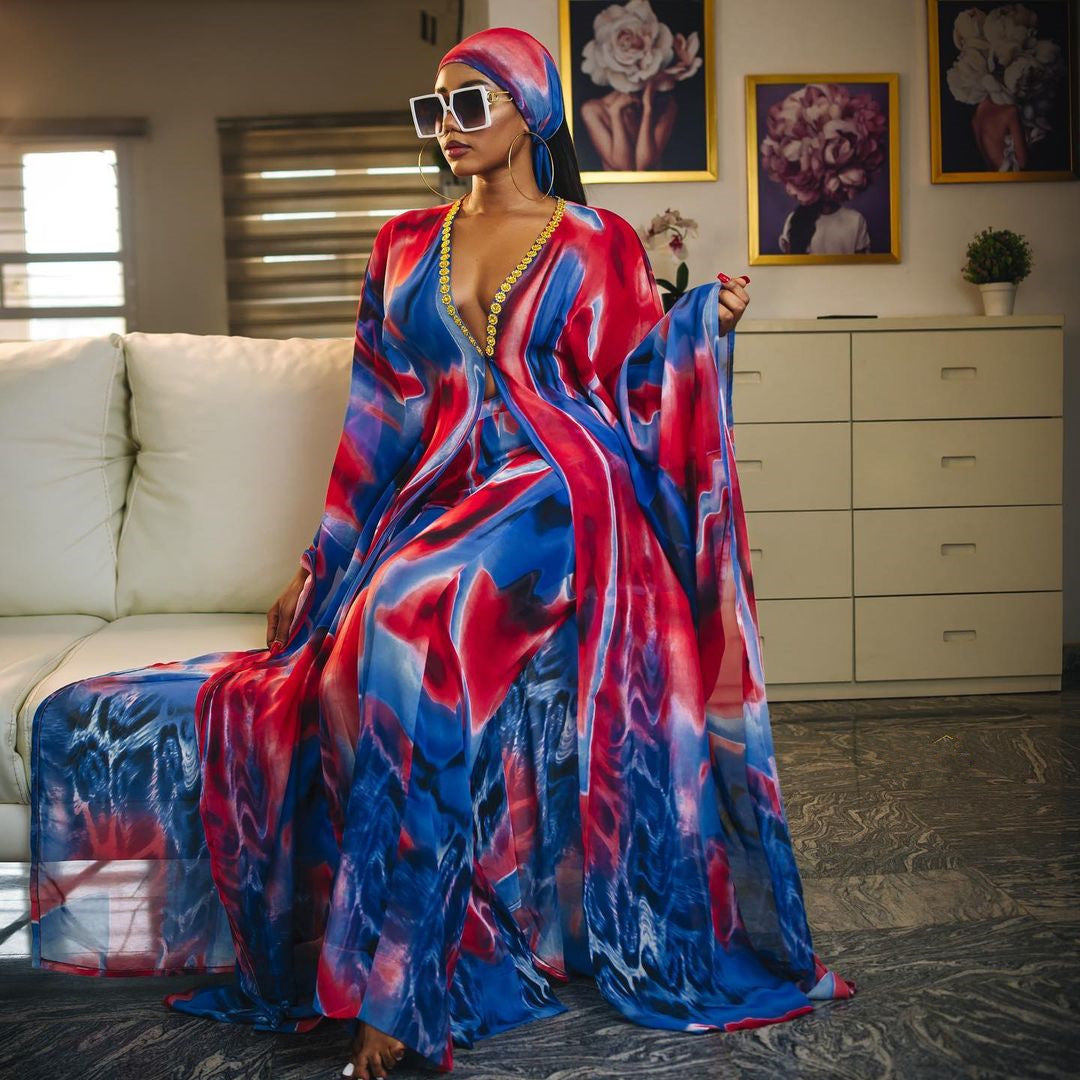 Woman in a colorful dress standing in a room with a couch and dresser.