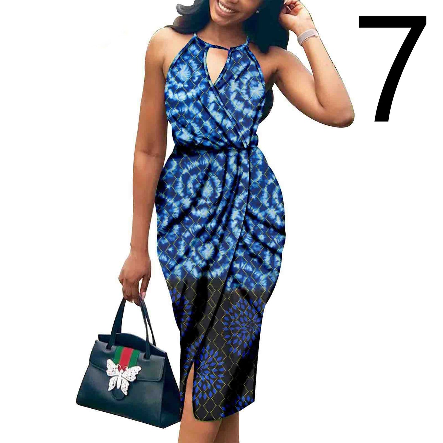 Woman wearing a blue and black patterned dress holding a Gucci handbag on a white background.