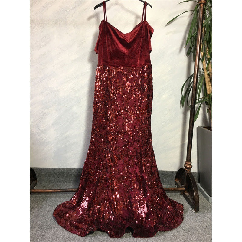 Red sequin dress on a hanger against a neutral wall.