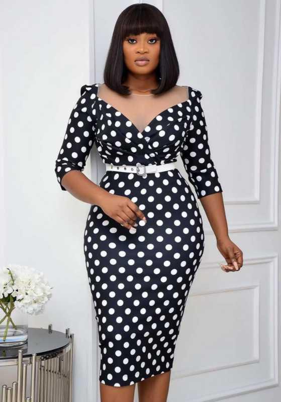 Woman wearing a black and white polka dot dress against a white background