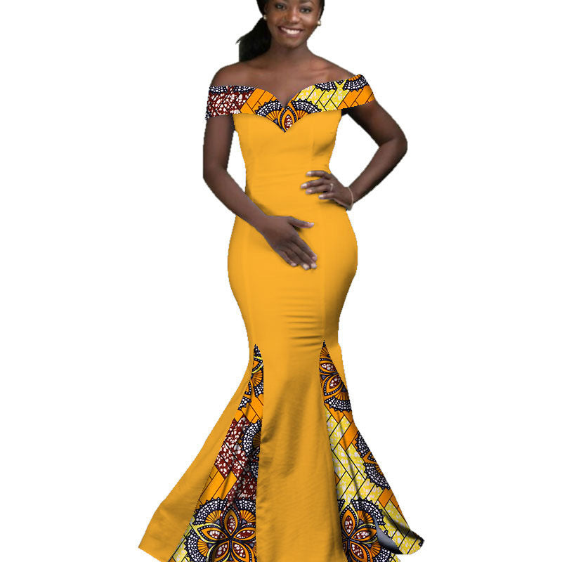 Woman wearing a yellow off-shoulder dress with intricate patterns on a white background