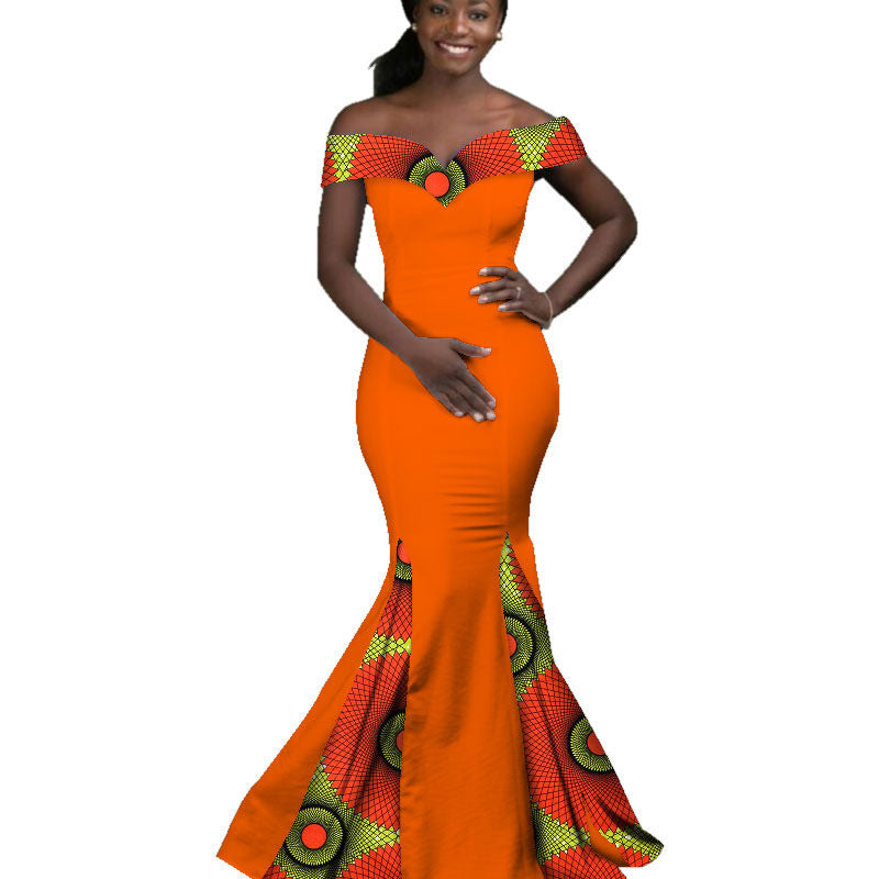 Woman wearing an orange dress with green and red patterns on a white background