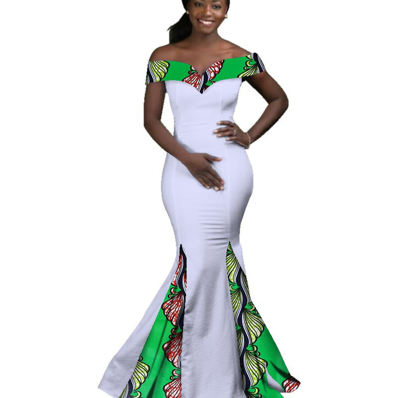Woman wearing a white dress with green and multicolor patterned top and bottom on a white background