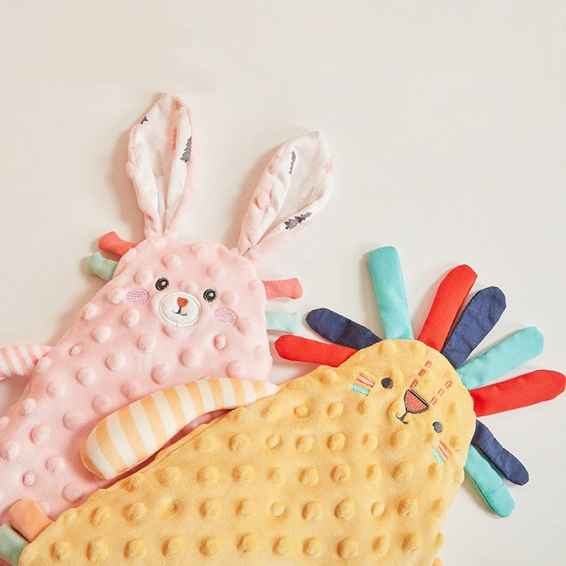 Two soft toys, a pink rabbit and a yellow lion, on a light background