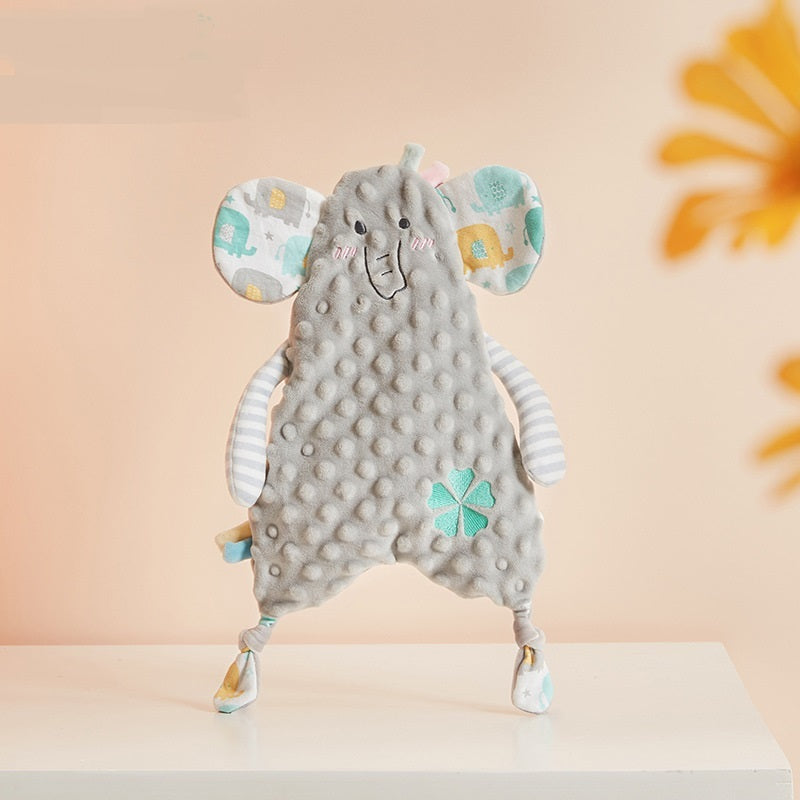 Gray elephant plush toy with colorful accents on a white surface against a peach background