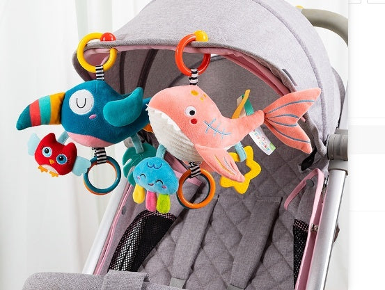 Colorful baby toy with fish and toucan designs attached to a stroller.