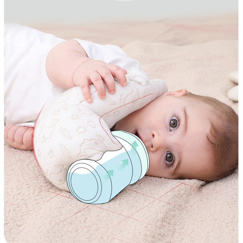 Baby lying on a beige blanket with a white plush toy and blue cup.