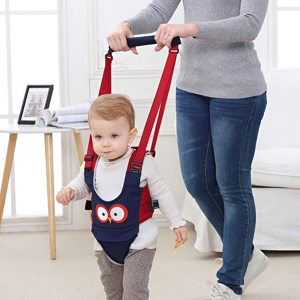 Child wearing a red and blue walker with an owl design, being held by an adult in a home setting.
