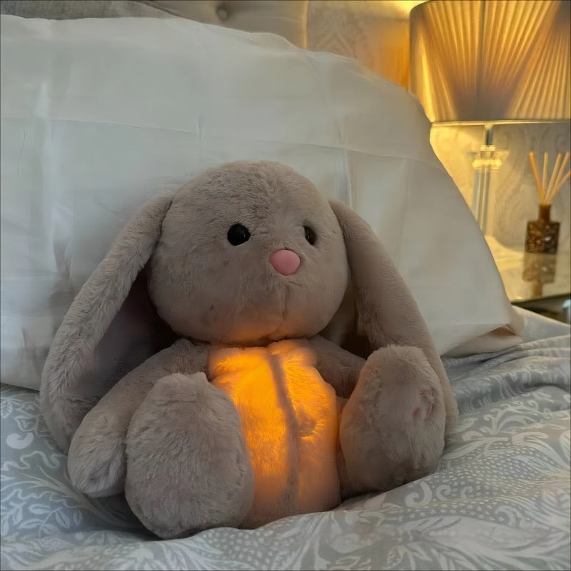 Plush bunny toy with glowing interior on a bed