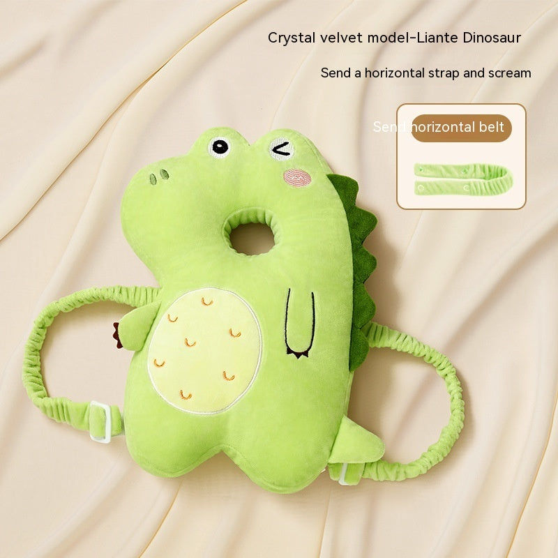 Green dinosaur-shaped pillow with straps on a beige background