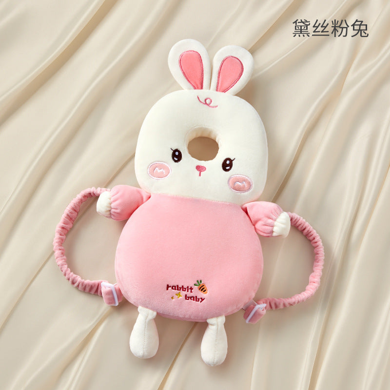 Pink bunny-shaped baby rattle on a beige background