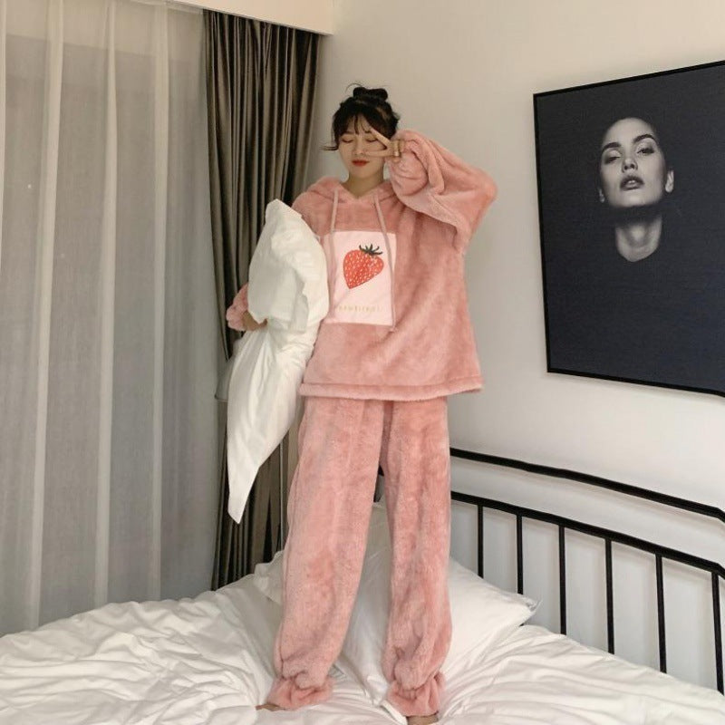 Person wearing pink pajamas with a strawberry design in a bedroom.