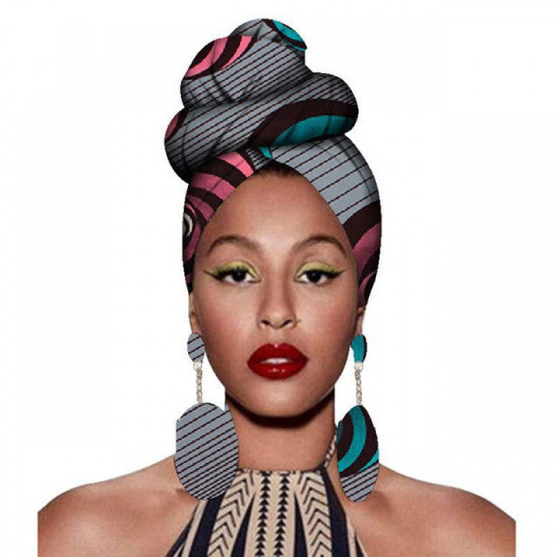 Woman wearing a colorful headscarf and earrings on a white background