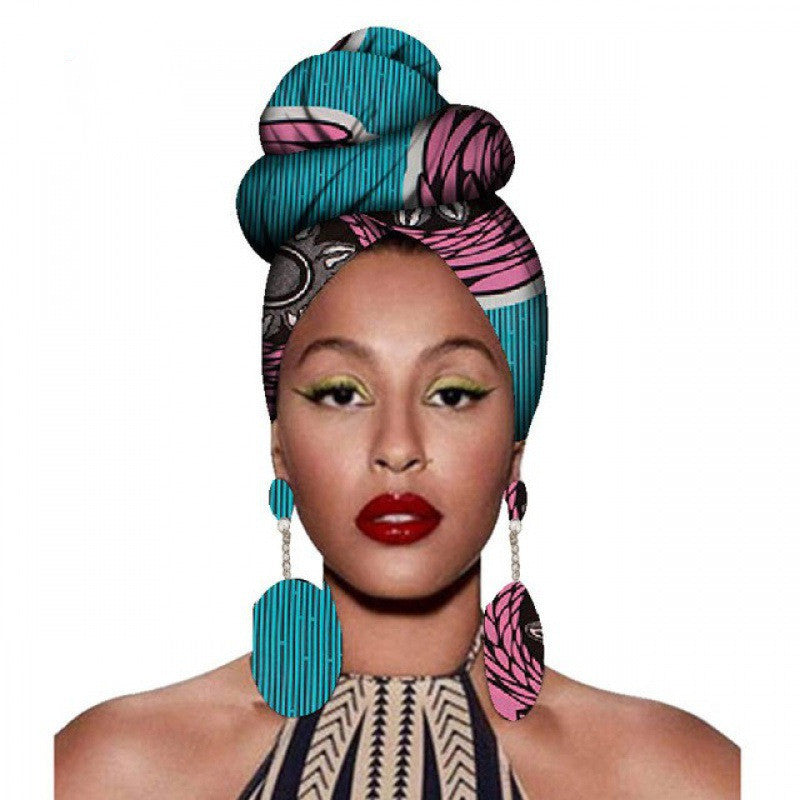 Woman wearing a colorful headscarf and earrings on a white background