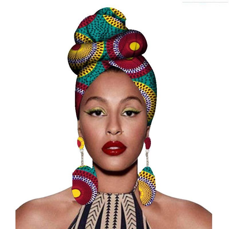 Woman wearing a colorful headscarf and earrings on a white background