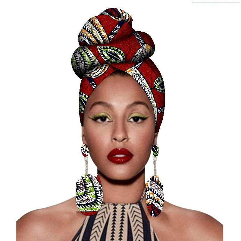 Woman wearing a colorful headwrap and earrings on a white background