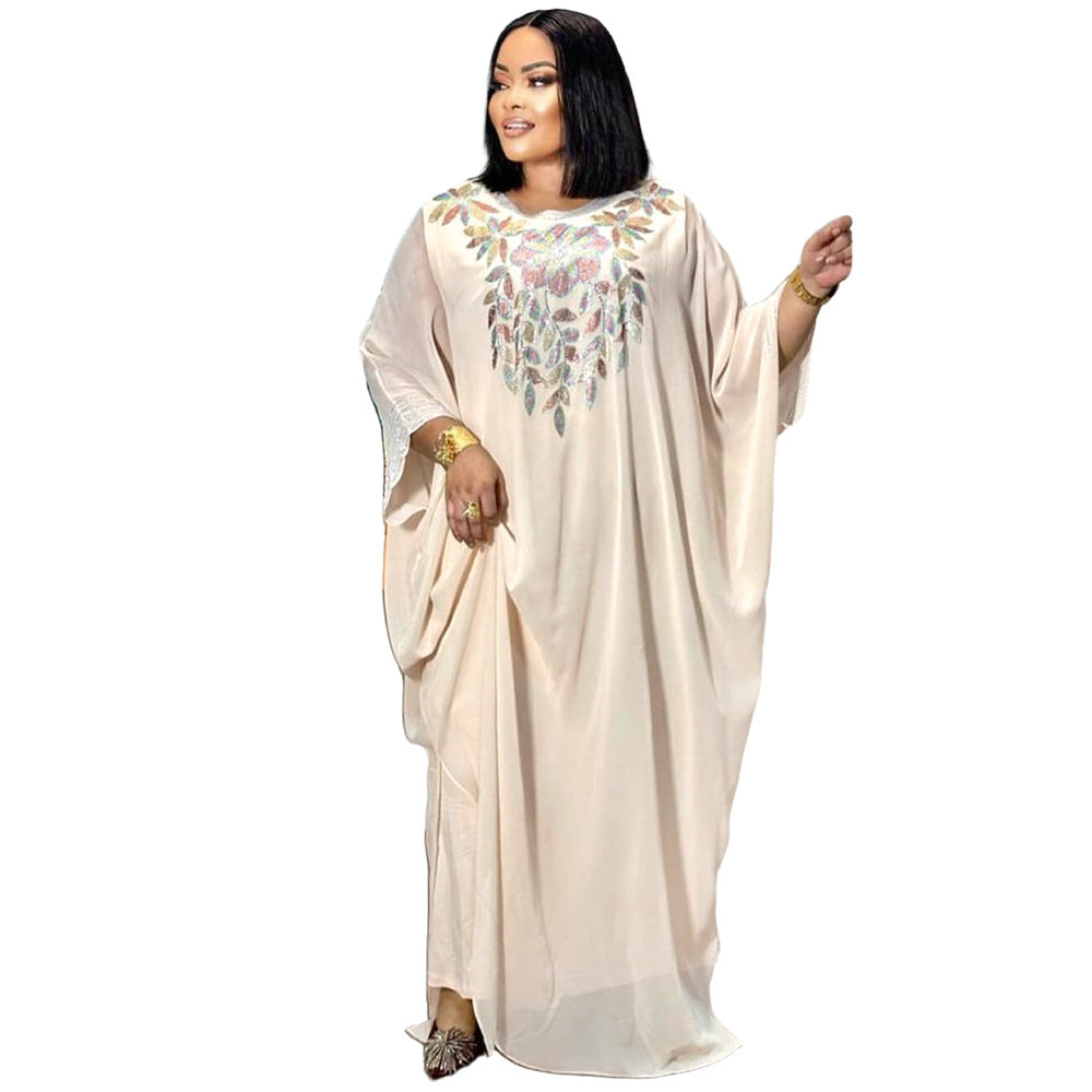 Woman wearing a beige dress with floral embroidery on a white background