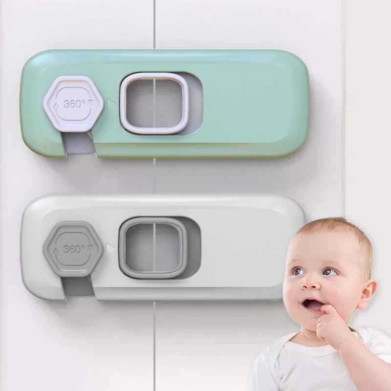 Two green and gray baby gate parts on a white wall with a baby looking up at them.