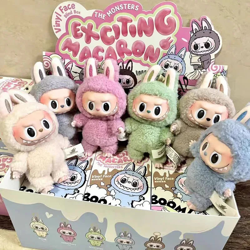 Box of colorful plush toys with a 'Vinyl Face' branding on a wooden surface.