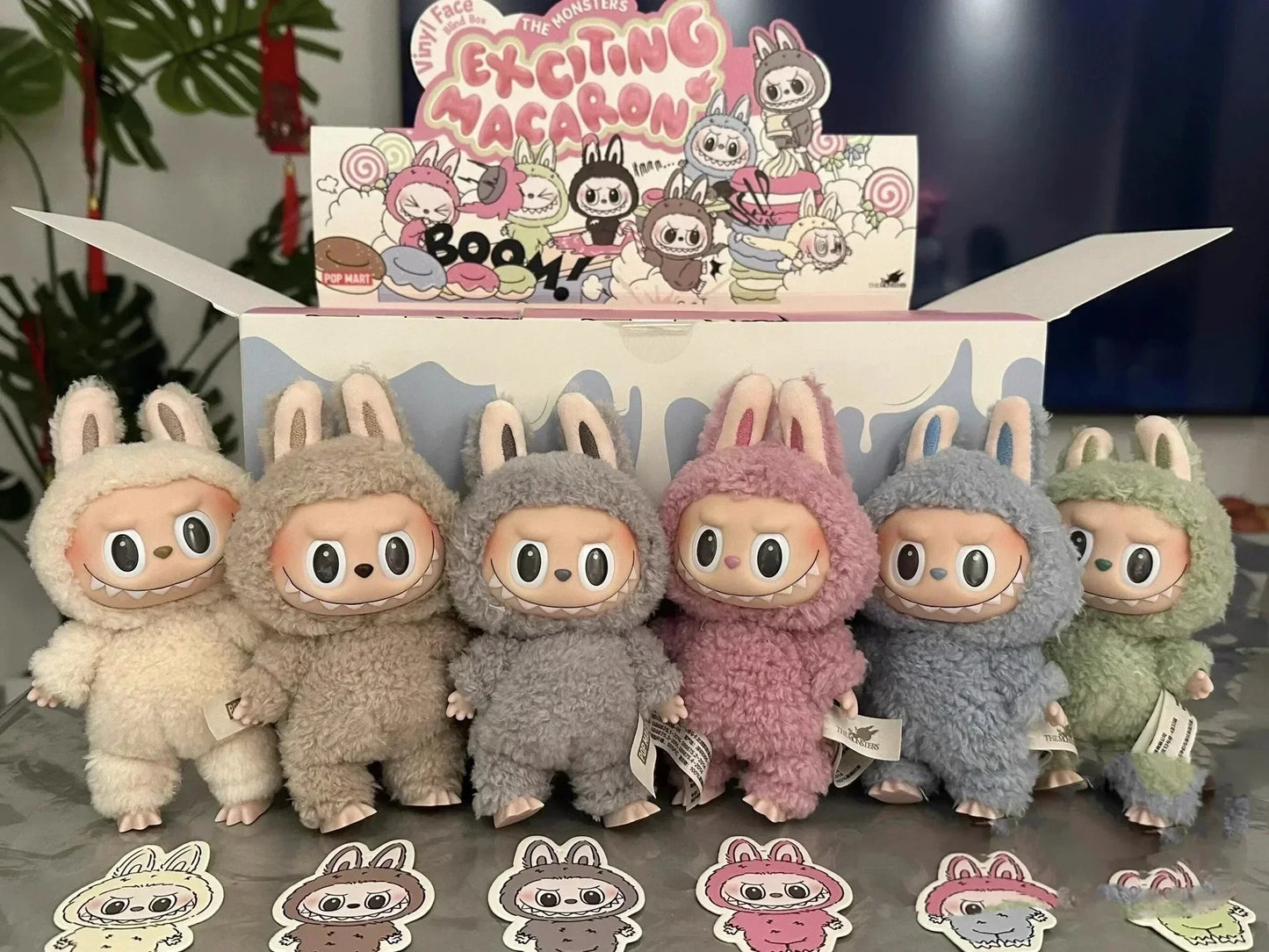 Set of plush toys in various colors with a box labeled 'Exciting Macaron' in the background.