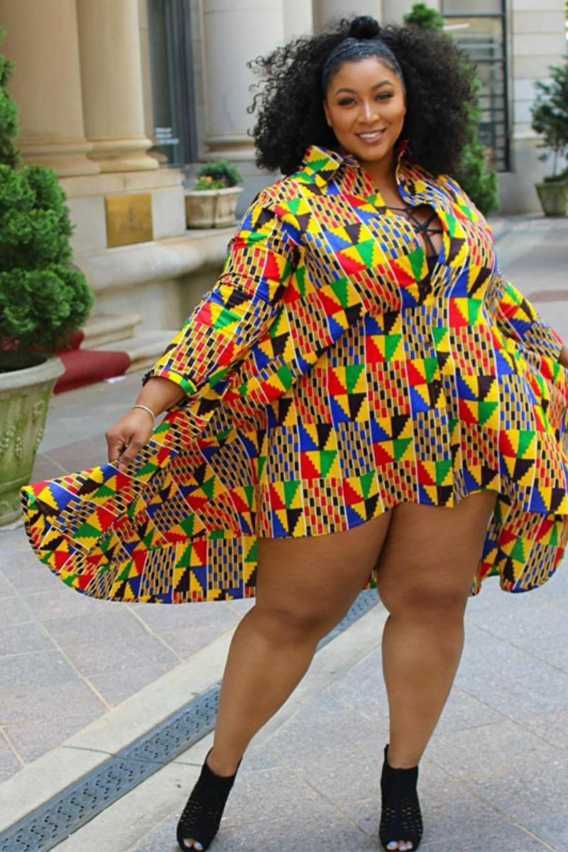 Woman wearing a colorful patterned dress standing outdoors.