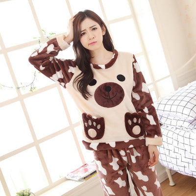 Woman wearing a brown and white cow-themed pajama set in a bright room.