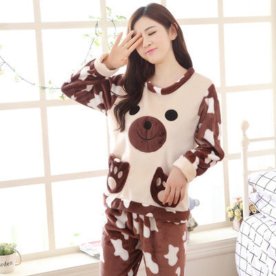 Woman wearing a cartoon bear pajama set in a room with a window and bed.