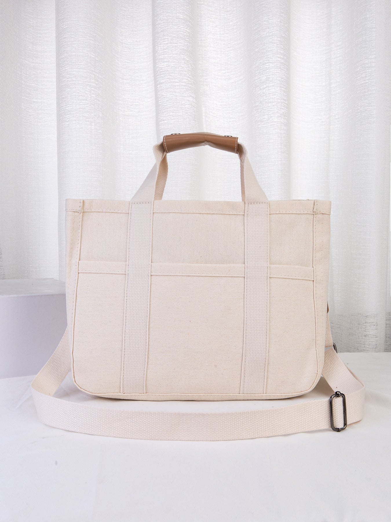 Beige tote bag with brown handle on a white background