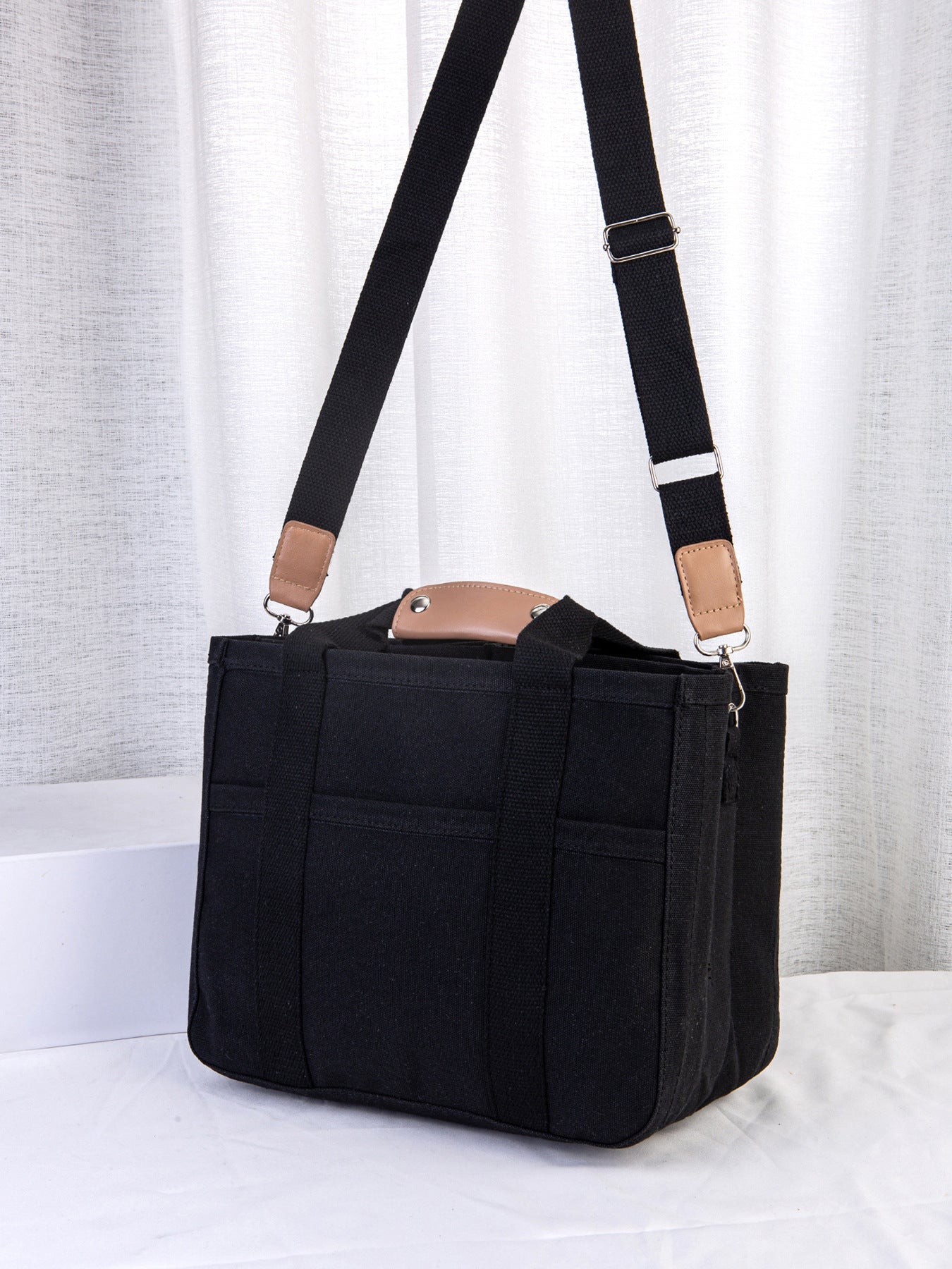 Black tote bag with a strap on a white background