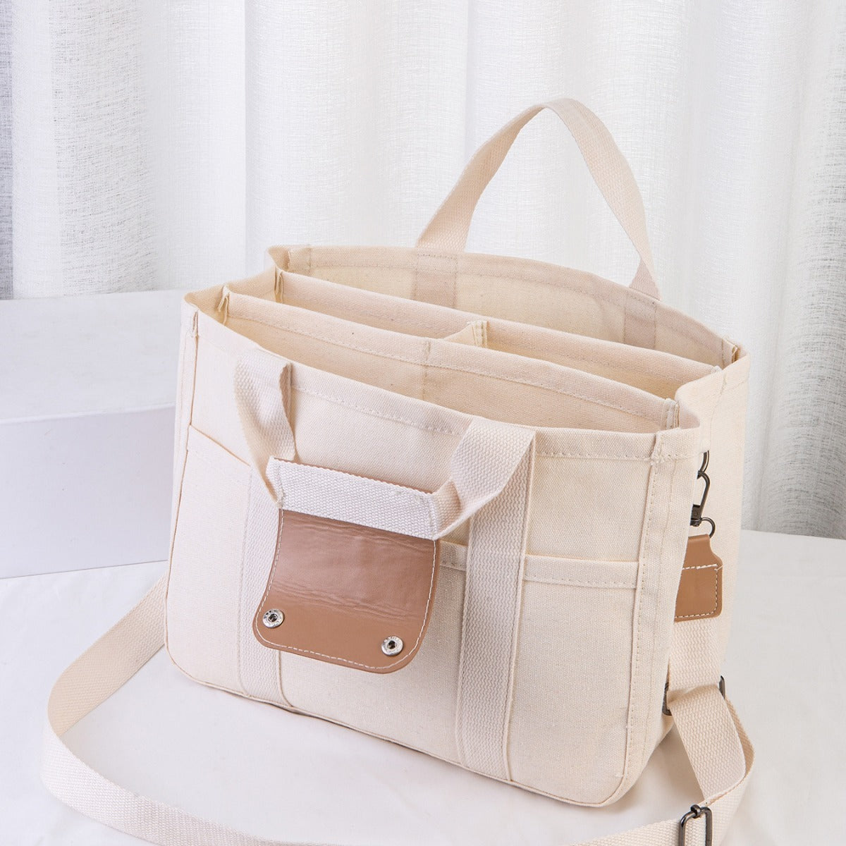 Beige tote bag with brown pocket on a white background