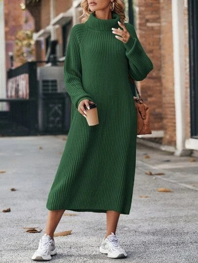 Woman wearing a green sweater dress with white sneakers on a street.