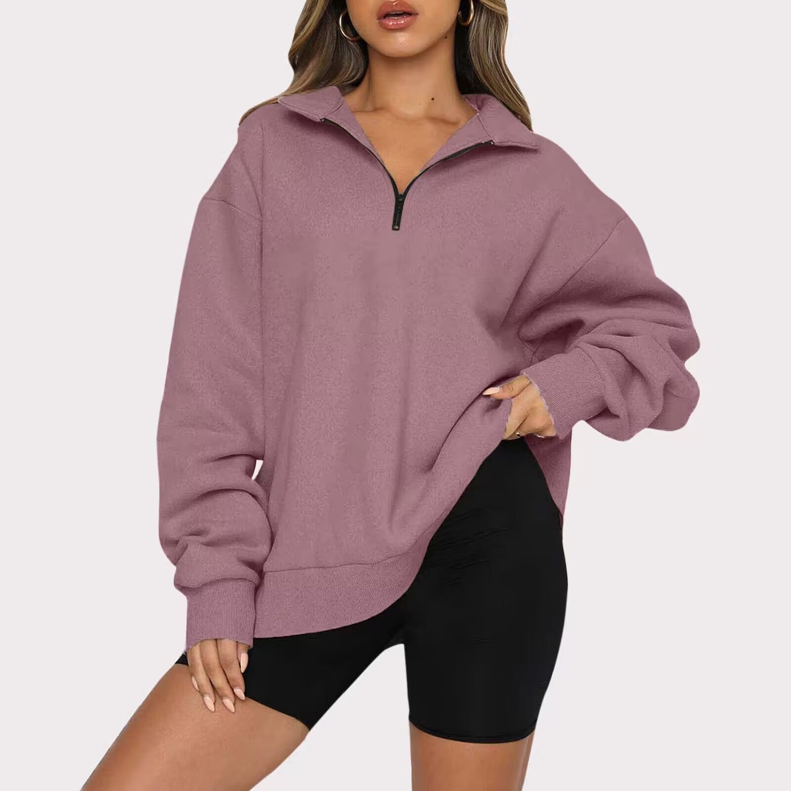 Person wearing a mauve hoodie and black shorts on a white background