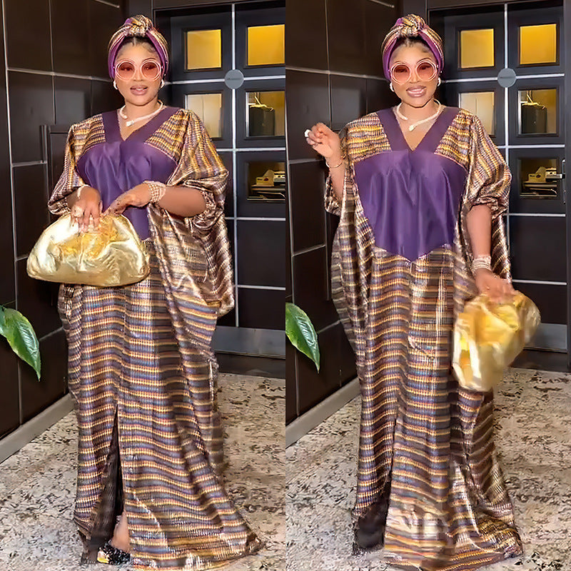 Woman in traditional attire holding a gold bag indoors.