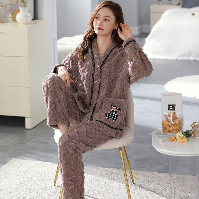 Woman wearing a brown flannel pajama set sitting on a chair in a bedroom.