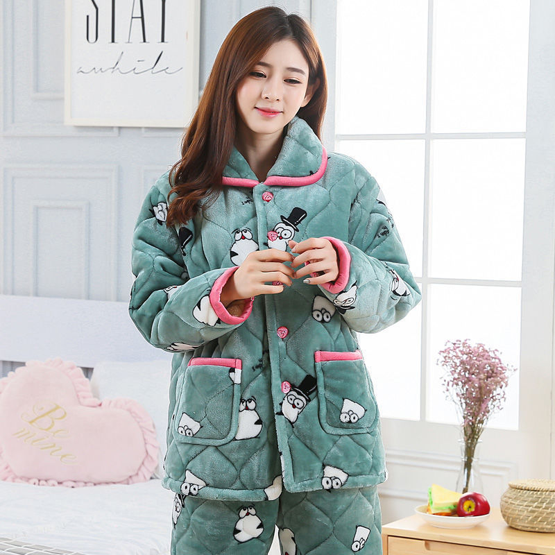 Woman wearing a green quilted pajama set with cartoon designs in a bright room.