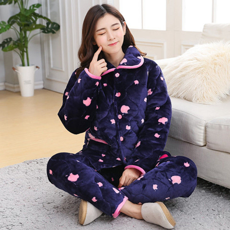 Woman wearing a navy blue pajama set with pink hearts in a living room.
