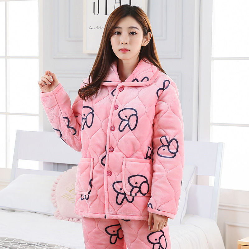 Person wearing a pink quilted jacket with cartoon designs in a bedroom setting