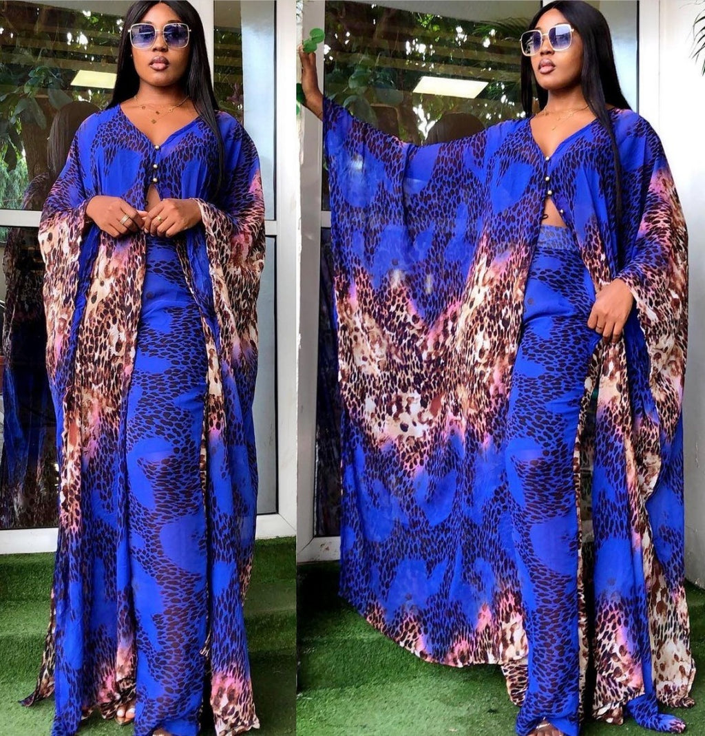 Woman wearing a blue and multicolor patterned outfit with sunglasses indoors.