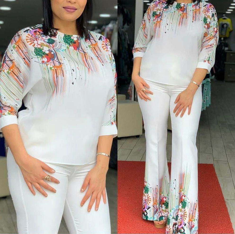 Woman wearing a colorful top and white pants in an indoor setting