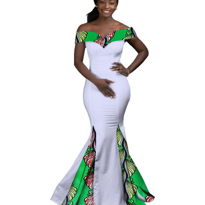 Woman wearing a white dress with green and multicolor patterned top and bottom on a white background