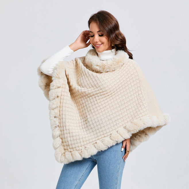 Woman wearing a beige poncho with white fur trim on a light gray background