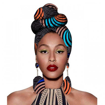 Woman wearing a colorful headwrap and earrings on a white background
