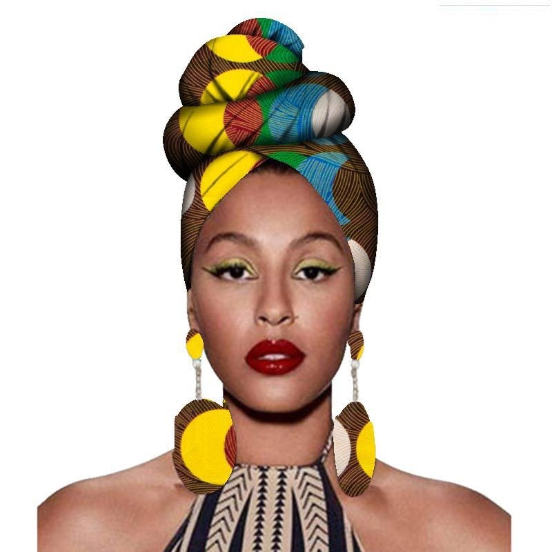 Woman wearing a colorful headwrap and large earrings on a white background