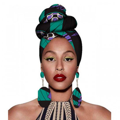Woman wearing a colorful headwrap and earrings on a white background