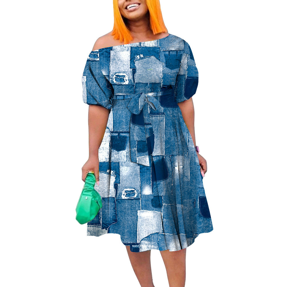 Woman wearing a blue patchwork dress holding a green bag on a white background