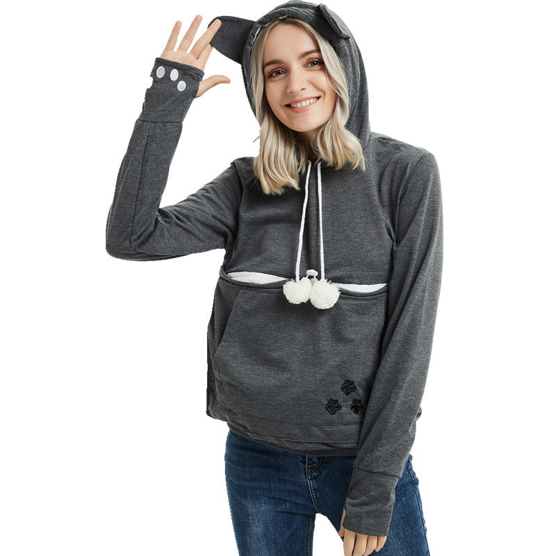 Woman wearing a gray hoodie with cat ears and tail on a white background