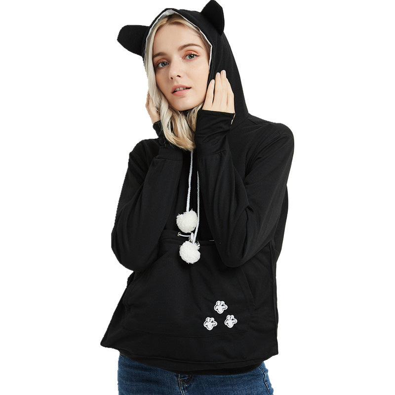 Person wearing a black hoodie with cat ears and paw prints on a white background