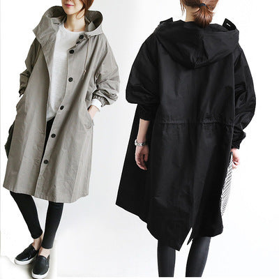 Two people wearing long coats, one gray and one black, on a white background.