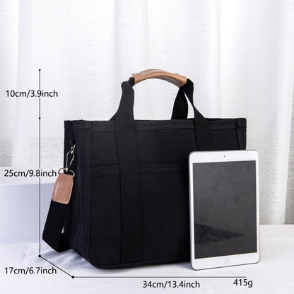 Black tote bag with measurements and an iPad for scale on a white background