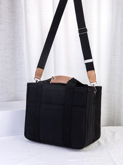 Black tote bag with a strap on a white background